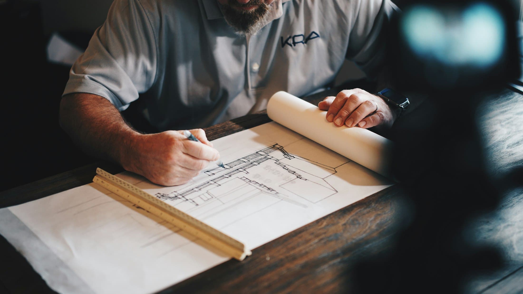 An architect drafting plans with a scale ruler